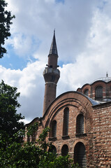 Brick wall of the old mosque and minaret. Cloudy day in Istanbul.