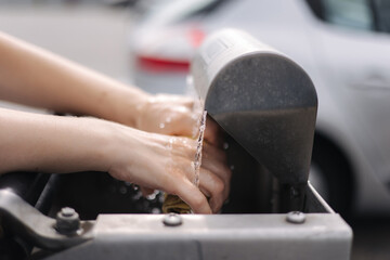 Female wash rug in water. Close-up woman's hand in front of car on sel servise car wash