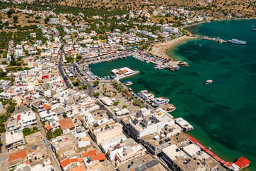 Naklejka na ściany i meble ELOUNDA, CRETE/GREECE - JULY 16 2021: Aerial view of the port and resort town of Elounda on the Greek island of Crete