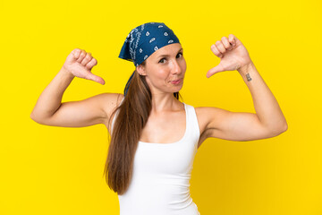 Young English woman isolated on yellow background proud and self-satisfied