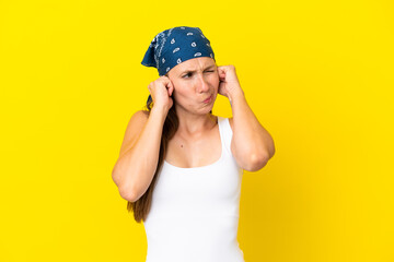 Young English woman isolated on yellow background frustrated and covering ears