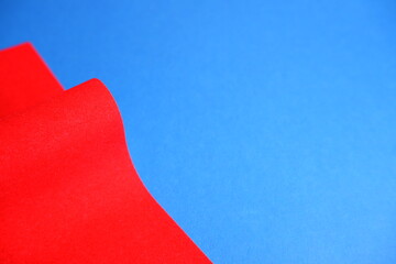 Red cardboard on a blue background. The texture of the cardboard.