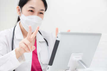 Doctor examine the patient via video call. Asian female doctor examines patients treatment, explains medicines and gives encouragement online. health care and prevention COVID-19 strategy concept