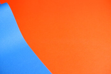 Blue cardboard on an orange background. The texture of the cardboard.