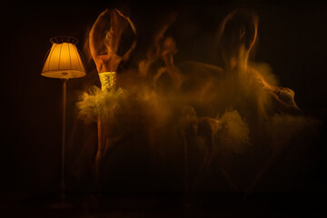 Long exposure of ballerina, dancers in movement in tutu with light on a black background. Both arms and a leg lifted up.
