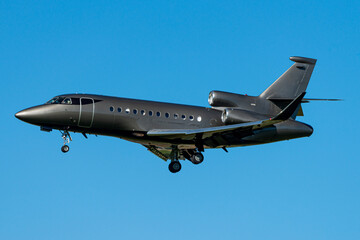 metallic private jet flying with a blue sky in the background - Powered by Adobe