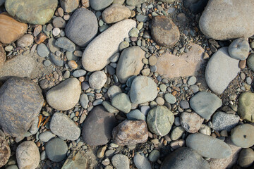Dry stones on the river bank. River stones of different sizes and colors.