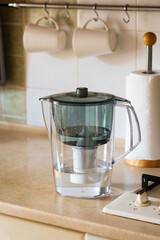 Water filter jug on kitchen table. Clean water concept. Filtration water