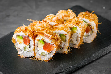 appetizing philadelphia sushi roll with tuna salmon avocado chips and cucumber on a black stone plate