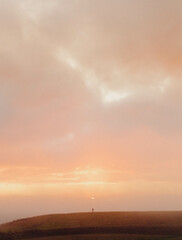 person standing on hill at sunset