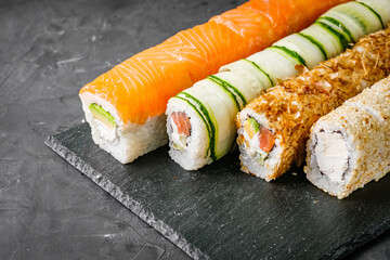 appetizing set of sushi roll on a black stone plate