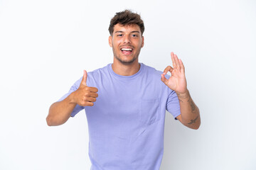 Fototapeta premium Young caucasian handsome man isolated on white background showing ok sign and thumb up gesture