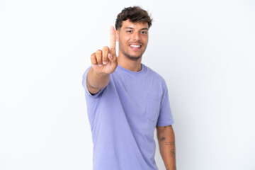 Naklejka premium Young caucasian handsome man isolated on white background showing and lifting a finger