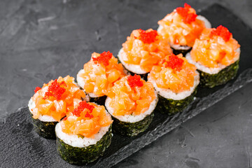 appetizing sushi roll maki with salmon on a black stone plate © Narsil