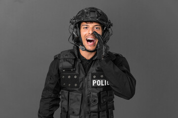 SWAT caucasian man isolated on grey background shouting with mouth wide open