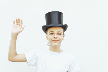 portrait of a happy smiling boy with a cylinder hat looking straight into the camera, a boy isolated on a white background 