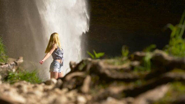 big waterfall behind blonde girl