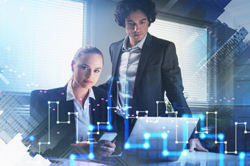 Businesswoman use smart phone and looking toward camera, businessman in formal suit is looking at laptop. Office background. overlay of digital forex financial charts