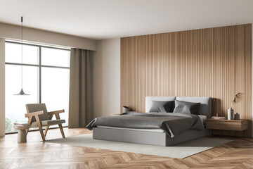 Corner view of light beige bedroom with grey bed, wood-panel wall