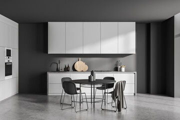 Simple grey kitchen with round black dining table