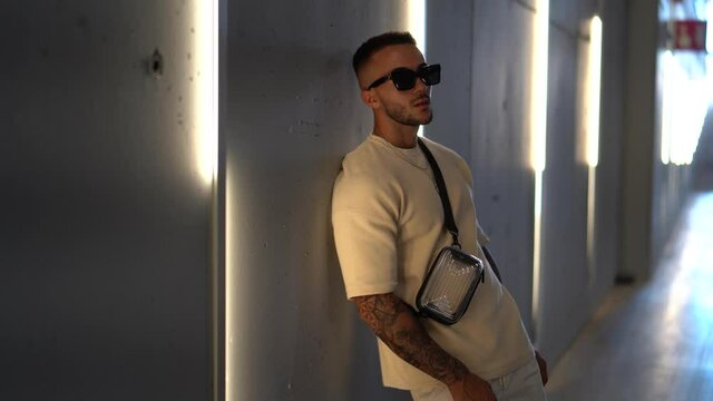 Chico joven atl&eacute;tico tatuado posando con ropa actual