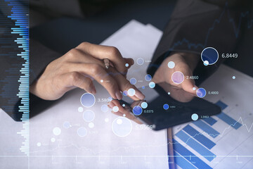 A woman financial trader in formal wear is checking the phone to sign the contract to invest money in stock market. Internet trading and wealth management concept. Forex hologram chart.