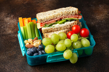 School, work lunch box with sandwiches and fresh vegetables, nuts and fruits. Healthy food.