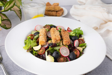 Green leafy salad, tomato, avocado, radishes, olives and tofu fingers. Vegetarian salad. Vegan food photography