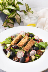 Green leafy salad, tomato, avocado, radishes, olives and tofu fingers. Vegetarian salad. Vegan food photography