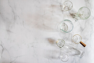 Set of glassware on white marble background. Glass, jar, bottle and cup. 