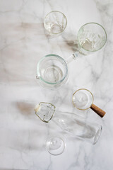 Set of glassware on white marble background. Glass, jar, bottle and cup. 