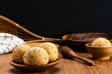Homemade delicious sesame mochi bun in wooden plate and in wooden cup .
