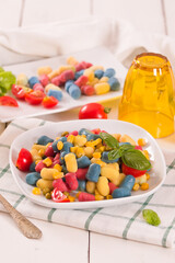 Colored gnocchi with vegetables and sweet corn.