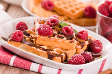 Waffles with raspberries and chocolate cream.