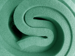 green foam sponge. a bundle of pastel color foam material with a beautiful spiral shape