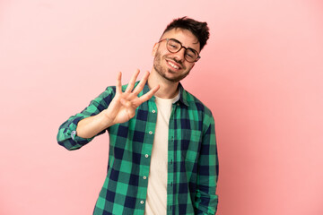 Fototapeta premium Young caucasian man isolated on pink background happy and counting four with fingers