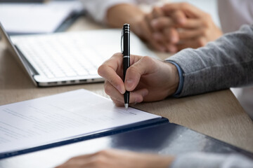 Crop close up of male employee worker put signature on document close deal at meeting in office....