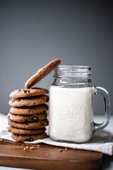 A stack of chocolate chip cookies with milk