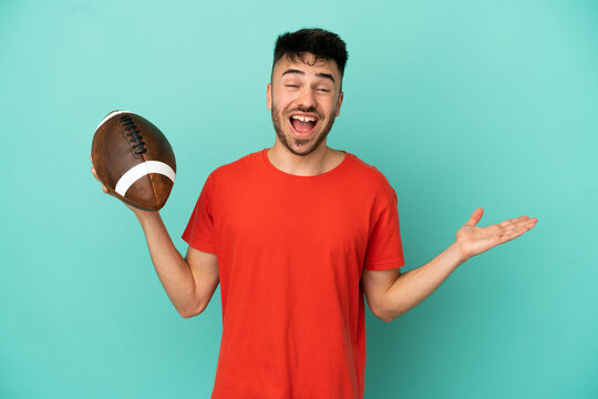 Young Caucasian man playing rugby isolated on blue background with shocked facial expression