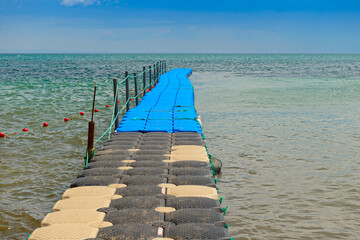 Pontoon bridge made of plastic cubes on the sea