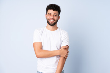 Young Moroccan man isolated on blue background laughing