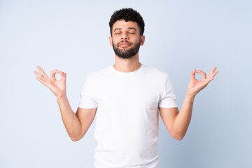 Fototapeta premium Young Moroccan man isolated on blue background in zen pose
