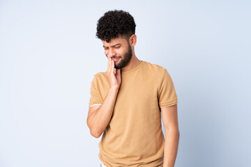 Young Moroccan man isolated on blue background with toothache