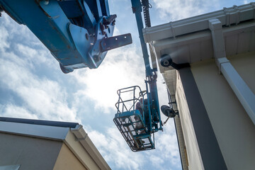 Worker on a aerial access platform, cherry picker, cleaning house