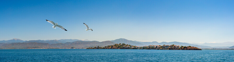 Fototapeta na wymiar Megri Island or Fethiye Island of the Gulf of Telmessos on exit to Fethiye Harbour, Turkey. Turkish Riviera, yachting and luxury sea vacation on the Aegean coast.