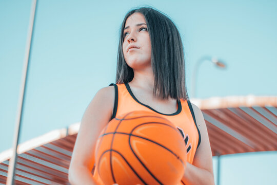 Mujer intrigada y joven jugando al baloncesto con una pelota en una pista de juego para encestar el balon en la canasta