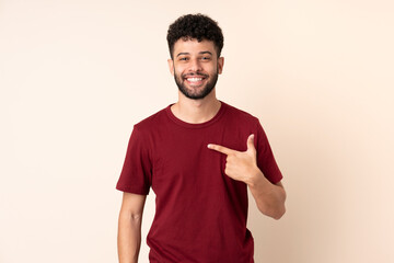 Young Moroccan man isolated on beige background pointing to oneself