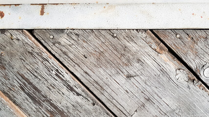 Gray wooden background with diagonal lines. Board background with copy space. Wooden old boards with cracked gray paint on the diagonal. Selective focus. Textured wooden background.