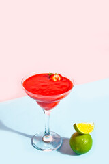 Cold strawberry margarita or daiquiri cocktail with lime and rum