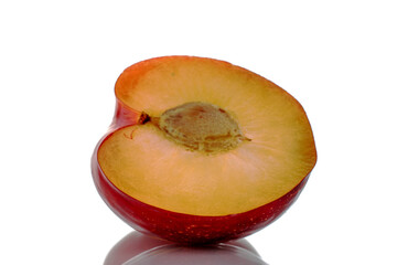 One half of ripe fragrant red plum, close-up, isolated on white.